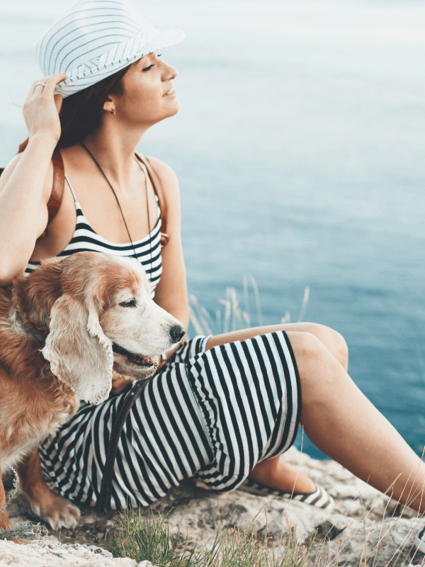 woman with a dog on beach, wind