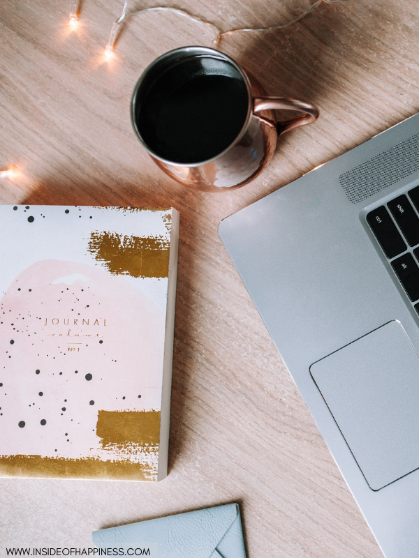 journal-on-a-table-next-to-coffee-and-laptop