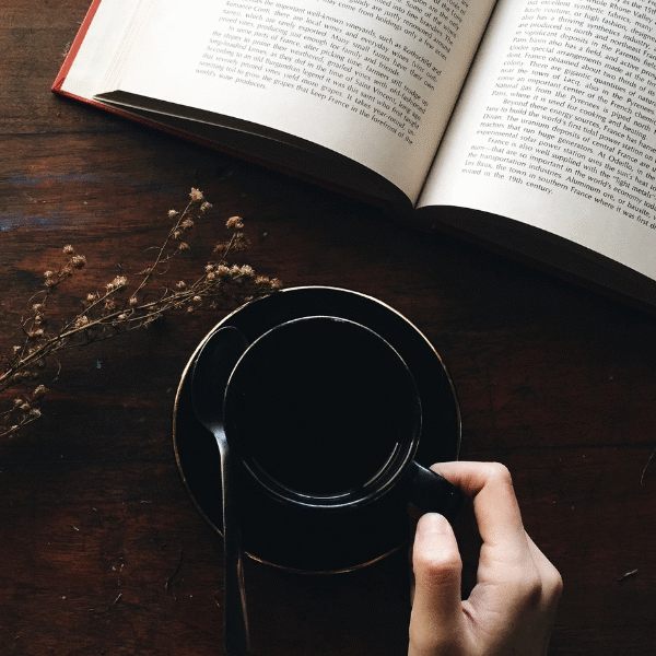 a-hand-holding-a-black-cup-of-coffee