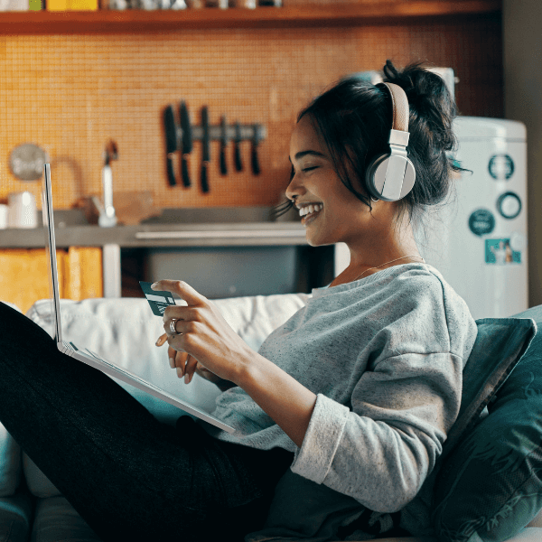 woman-smiling-listening-to-music-on-the-couch