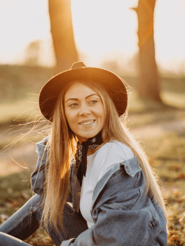 smiling-woman-wearing-a-hat-in-the-woods