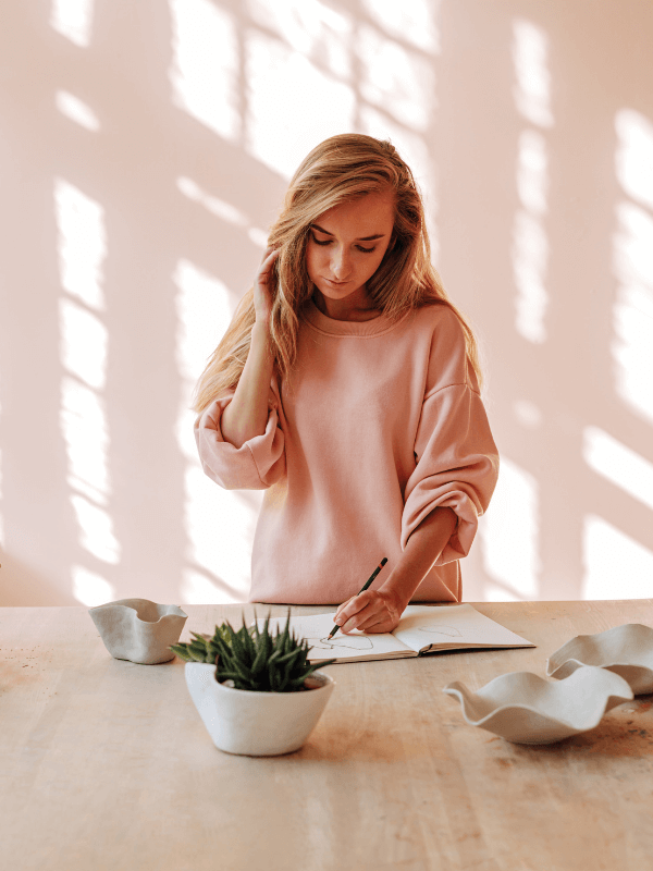 woman-writing-in-a-journal-on-the-kitchen-countertop