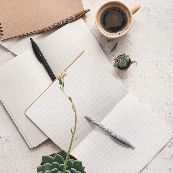open-notebook-on-a-desk-with-a-coffee