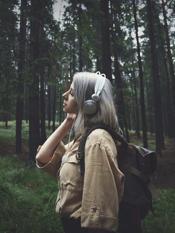 woman-listening-to-heaphones-in-the-woods