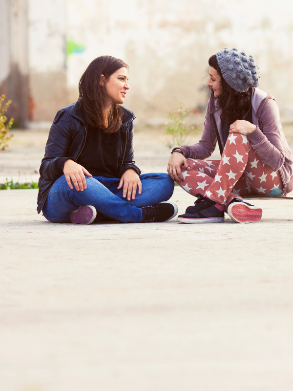 friends sitting on the ground chatting