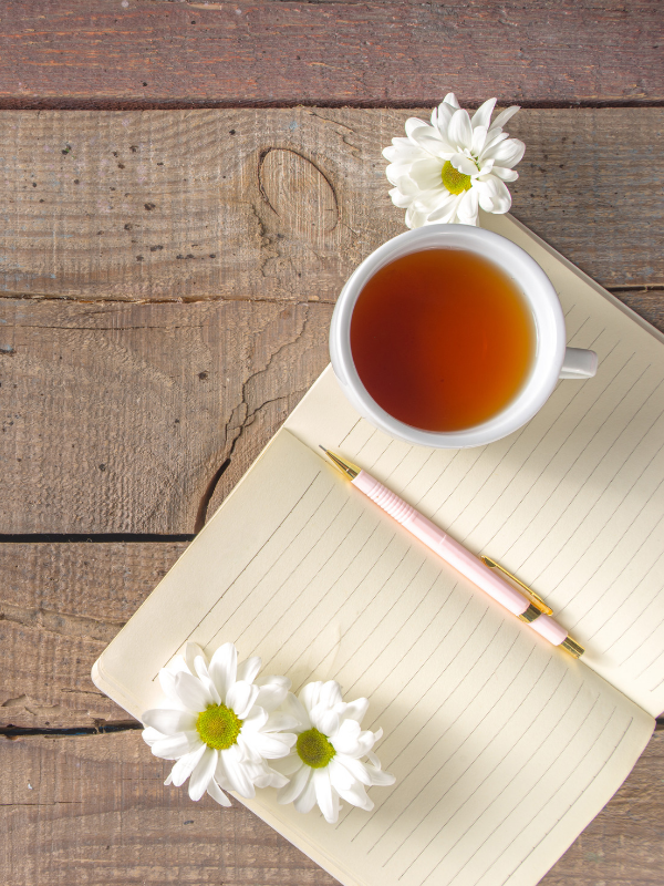 open notebook and herbal tea cup