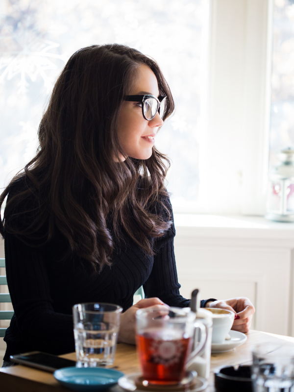 woman in a coffee shop sittin on a table