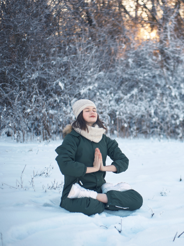 woman meditating in the snow
