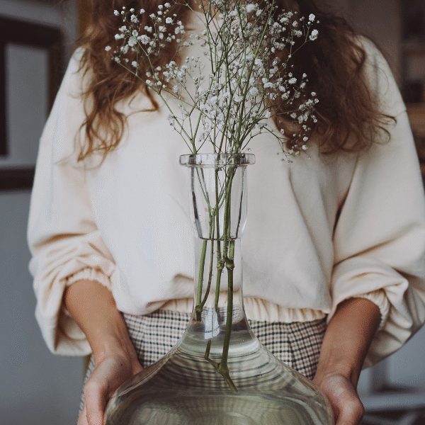 woman holding a vase with flower