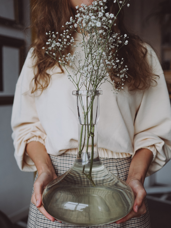 woman holding a vase with flower
