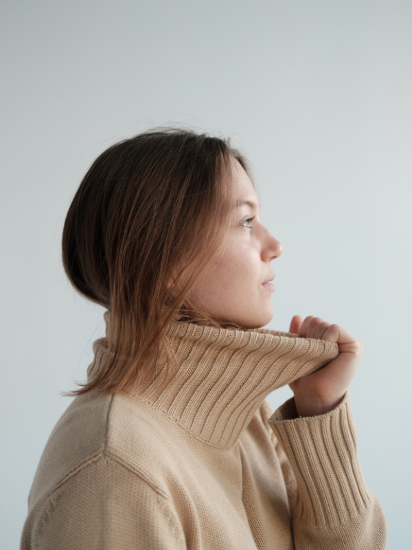 woman with a thick sweater looking away