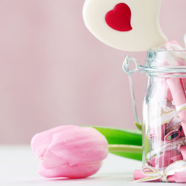 clear jar full with pink pieces of paper with gratitude notes