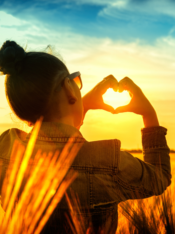 woman with hands shaping heart