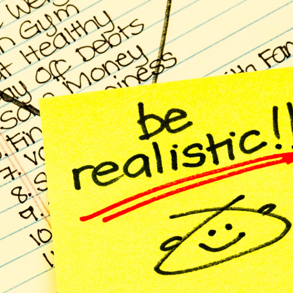featured image of a new years list of resolutions with a post-it note that says be realistic on top of that list