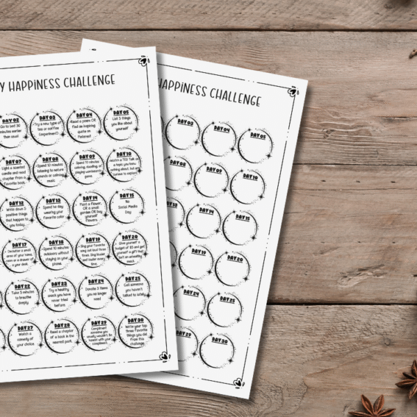 printed papers with a 30-day happiness challenge on a flat desk next to cozy candles