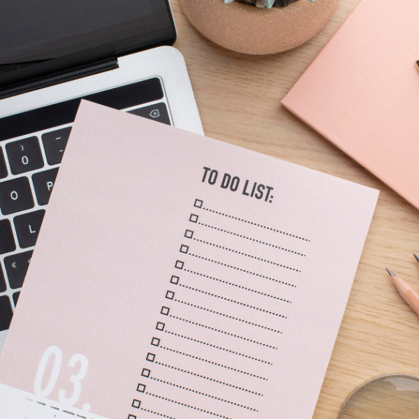 featured image of an open laptop and placed to-do list planner on top of it, on the side a several stationary elements such as notes, pens