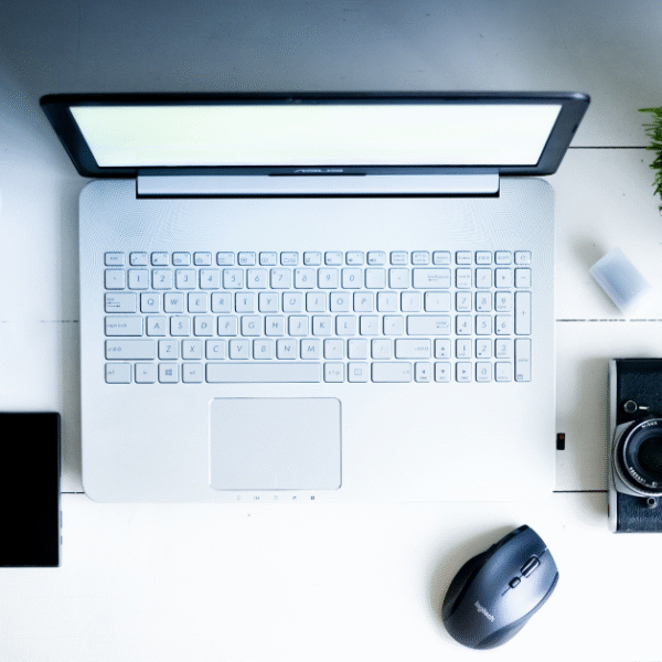 featured image for post on digital declutter and detox showing a desk top and a laptop, phone, camera, plant and headphones flat lay